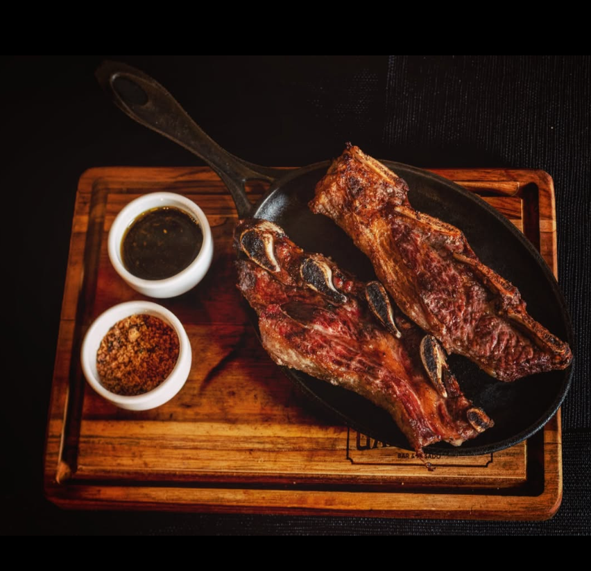 Costela bovina assada em frigideira de ferro com molho chimichurri e farofa