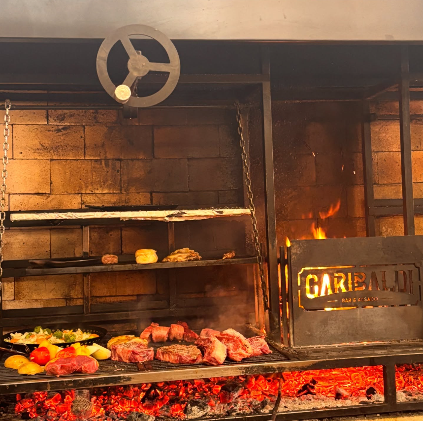 Parrilla de carvão do Garibaldi com carnes nobres, legumes grelhados e logo iluminado